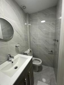 a bathroom with a sink and a toilet and a mirror at One Bedroom Apartment in Luton Town Centre in Luton