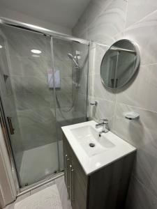 a bathroom with a shower and a sink and a mirror at One Bedroom Apartment in Luton Town Centre in Luton