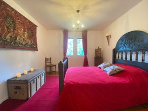 ein Schlafzimmer mit einem großen Bett mit einer roten Decke in der Unterkunft Au Temps Des Chevaliers in Pau