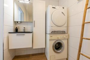 a small kitchen with a washing machine and a washer at Welcome in - Vakantiehuis - Achterweg 10 Zonnemaire ' Sol e Mar' in Zonnemaire