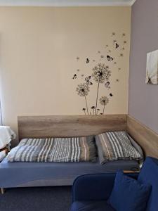 a bedroom with a bed with dandelions on the wall at Pension Kachlicka in Skála