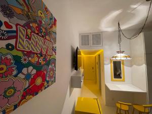 een kamer met een schilderij aan de muur en gele stoelen bij STUDIO12 in Petrópolis