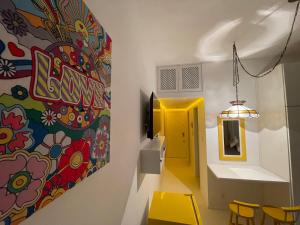 a room with a painting on the wall and yellow chairs at STUDIO12 in Petrópolis