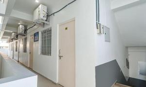 a hallway of a hospital with white walls and doors at FabExpress Ashiyana Inn in Patna +16 photos