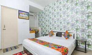 - une chambre avec un lit et un mur dans l'établissement Via Ashiyana Inn, à Patna