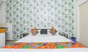 une chambre avec un lit avec une couette colorée dans l'établissement Via Ashiyana Inn, à Patna 20 autres photos
