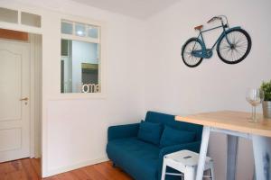 a blue couch in a living room with a bike on the wall at Lisbon Historic Center Apartment in Lisbon