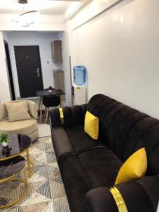 un soggiorno con divano nero e cuscini gialli di Furnished apartment in Lavington a Nairobi