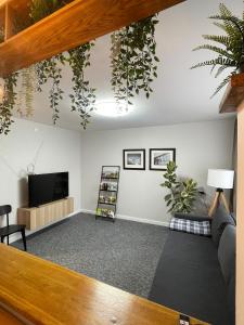 a living room with plants hanging from the ceiling at ROTUŠĖS g 23 APARTMENTS IN THE CITY CENTER BIRŽAI in Biržai