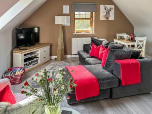 a living room with a gray couch and red pillows at The Snug in Harthill