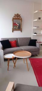 uma sala de estar com um sofá e duas mesas em Saint-Jean de Luz, proche du centre ville - 2/4 personnes - 3* em Sainte-Barbe