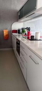 uma cozinha com bancadas brancas e electrodomésticos em Saint-Jean de Luz, proche du centre ville - 2/4 personnes - 3* em Sainte-Barbe