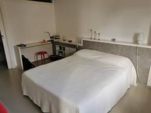 um quarto com uma cama branca num quarto em Saint-Jean de Luz, proche du centre ville - 2/4 personnes - 3* em Sainte-Barbe