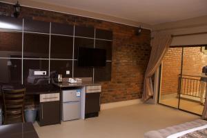 een kamer met een keuken met een bakstenen muur bij Exquisite executive room for 2 - 2179 in Kingsmead