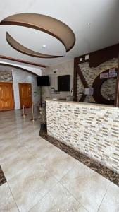 een lobby met een bar met een stenen muur bij روز للشقق الفندقية 3 in Hotat bani tamim