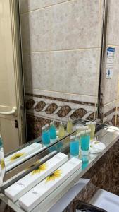 een aanrecht met drie borden met blauwe en gele glazen bij روز للشقق الفندقية 3 in Hotat bani tamim