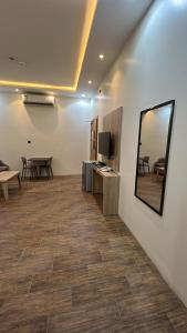 Habitación con espejo, mesa y TV. en روز الخيال للشقق المخدومة 3, en Hotat bani tamim 9 fotos más