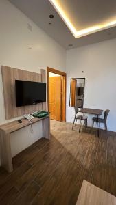 een woonkamer met een flatscreen-tv en een tafel bij روز للشقق الفندقية 3 in Hotat bani tamim
