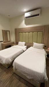 een hotelkamer met 2 bedden en airconditioning bij روز للشقق الفندقية 3 in Hotat bani tamim