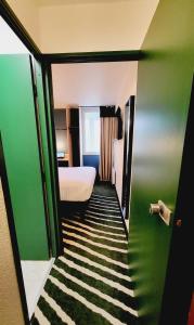 a small room with a bed and a green wall at Hotel Joinville Hippodrome in Joinville-le-Pont