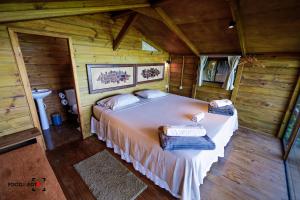 a bedroom with a bed in a wooden cabin at Espaço AVIVA in Florianópolis