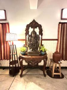 a table with a statue on it in a room at La Ruelle Guest House in Puducherry