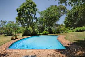 a small swimming pool on a brick patio at The River Cottage in Muldersdrift