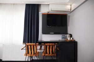 Habitación con bar con 2 sillas y TV. en GRAND ONUR HOTEL en Estambul