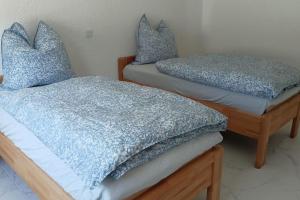 two beds with blue pillows on them in a room at Ferienhaus Südschwarzwald in Eggingen