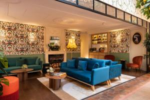 a living room with blue couches and tables at Royal Madeleine Hotel & Spa in Paris