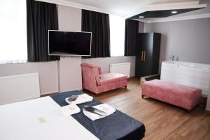 ein Hotelzimmer mit einem Bett, einem Stuhl und einem TV in der Unterkunft GRAND ONUR HOTEL in Istanbul