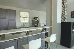 a kitchen with two white chairs and a counter at Ferienhaus Südschwarzwald in Eggingen