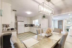a kitchen with white cabinets and a table and chairs at Beachy Keen in Jacksonville Beach