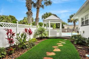 a garden with a gazebo and a pool at Beachy Keen in Jacksonville Beach