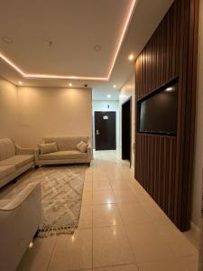 a living room with a couch and a flat screen tv at عليل الريف للشقق المخدومة in Al Baha +30 photos