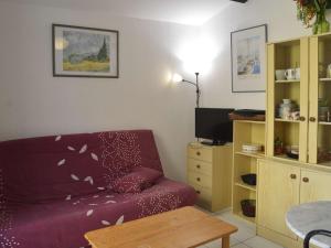 salon z fioletową kanapą i stołem w obiekcie Appartement Cap d'Agde, 3 pièces, 7 personnes - FR-1-249-44 w Cap d'Agde