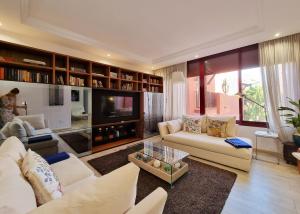 ein Wohnzimmer mit Sofas und einem TV in der Unterkunft Luxury Apartment in Jardines De Don Carlos in Marbella