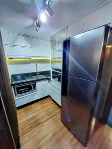 een keuken met een roestvrijstalen koelkast bij Bonaparte hotel D411 in Brasilia