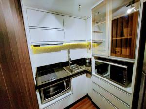een kleine keuken met witte kasten en een wastafel bij Bonaparte hotel D411 in Brasilia