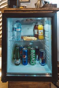 an open refrigerator filled with soda cans and drinks at Leda Stone House in Nevsehir