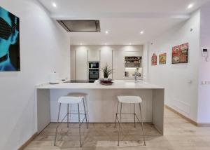 eine Küche mit einer großen Insel mit Barhockern in der Unterkunft Luxury Apartment in Jardines De Don Carlos in Marbella