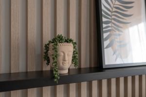 a vase on a shelf with a plant on it at Elegant Apartment for 4 with Parking in Poznan by Renters in Poznań