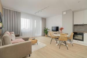 una sala de estar con un sofá y una mesa en Elegant Apartment for 4 with Parking in Poznan by Noclegi Renters, en Poznan