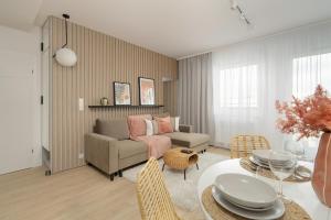 una sala de estar con un sofá y una mesa en Elegant Apartment for 4 with Parking in Poznan by Noclegi Renters, en Poznan