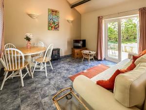 ein Wohnzimmer mit einem Sofa und einem Tisch in der Unterkunft Blossoms Cottage in Albourne