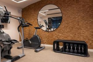 a gym with a mirror and exercise equipment at Royal Madeleine Hotel & Spa in Paris