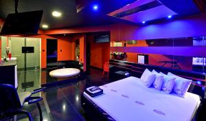 a bedroom with a bed with a purple lighting at Motel Deslize Ribeirão Preto in Ribeirão Preto