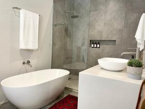 a bathroom with a white tub and a shower at Hilltop 39, Oubaai Golf Estate in Herolds Bay