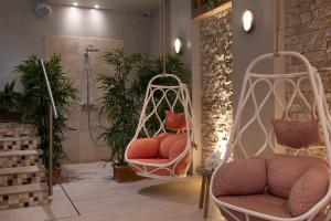 a room with two swinging chairs and a shower at Royal Madeleine Hotel & Spa in Paris
