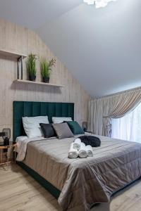 a large bed with a green headboard in a bedroom at Resto Park Традиція in Podvorki